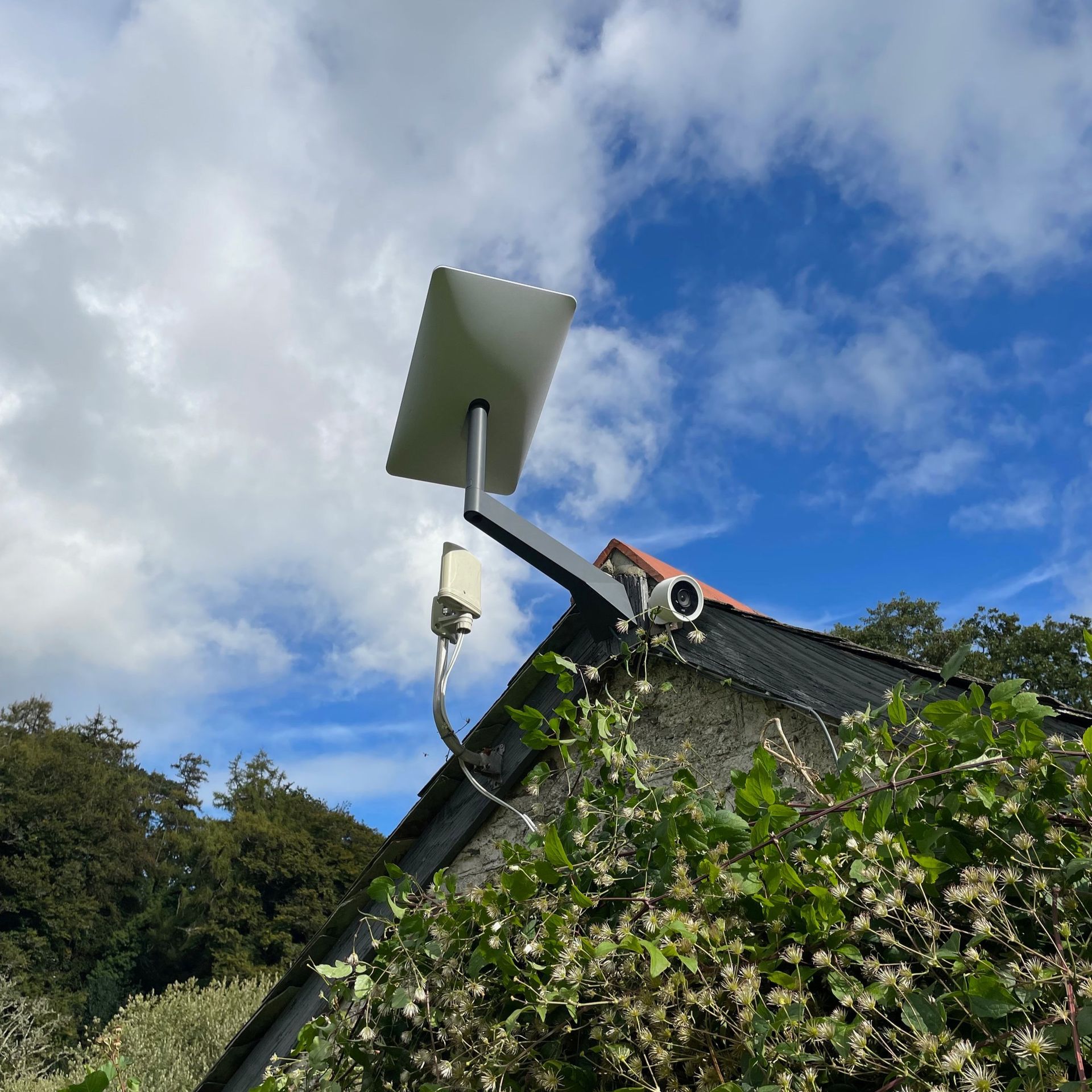 Starlink dish installed and mounted on the peak of a barn